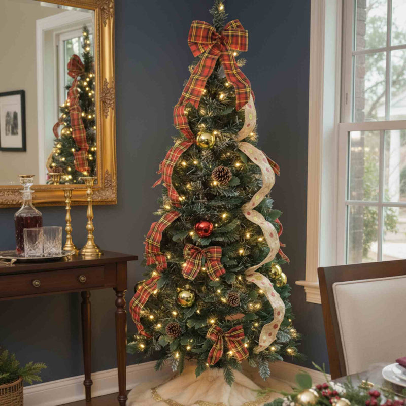 Decorated Christmas tree with lights, ribbons, and ornaments in a room with a mirror and table.