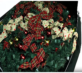Decorated Christmas tree with red and gold ribbons and ornaments in a black bag.